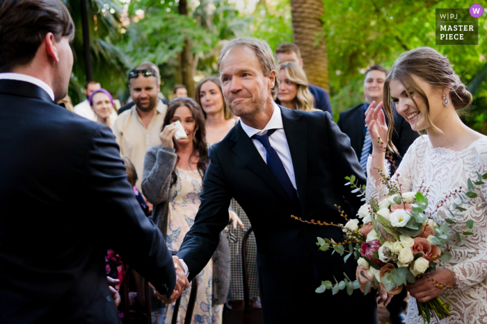 Imagem vencedora do concurso de fotografia de casamento documental de Perth do pai da noiva e do noivo apertando as mãos