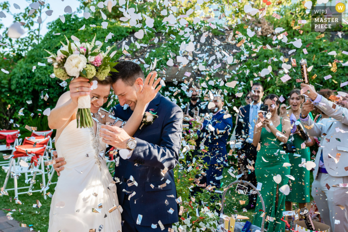 Madrid-documentaire-stijl trouwfoto uit Spanje van het bruidspaar dat de confetti afstoot die na de ceremonie op hen is verspreid