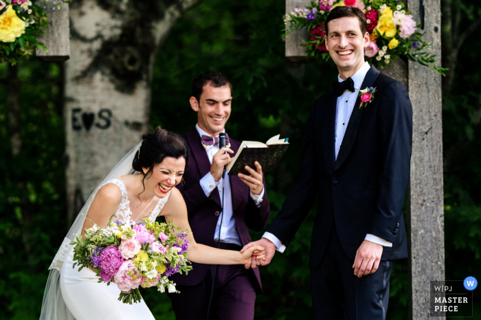 World-class documentary wedding image from the Alerin Barn in St Johnsbury, Vermont created as The couple laughs during their ceremony World-class documentary wedding image from the Alerin Barn in St Johnsbury, Vermont created as The couple laughs during their ceremony