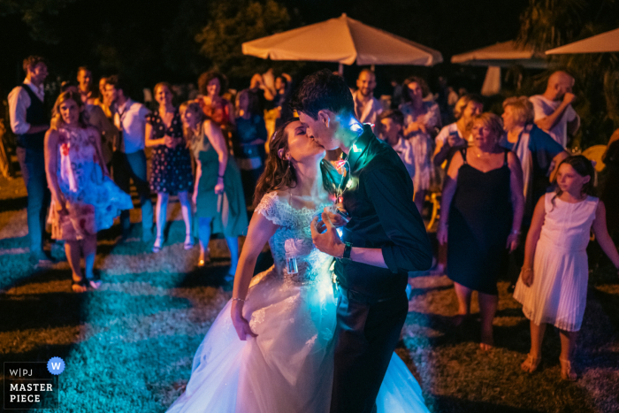 Top photographie de mariage naturel en Vénétie montrant les deux époux appréciant leur première danse car ils voulaient une atmosphère sombre pour mettre en valeur les lumières sur leur cou