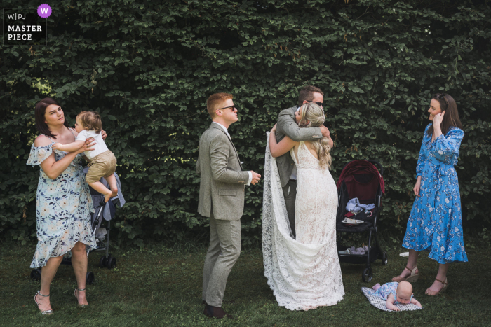 Fotografia em estilo documentário de um casamento em Lanouaille, França, capturando a noiva e os convidados durante o coquetel