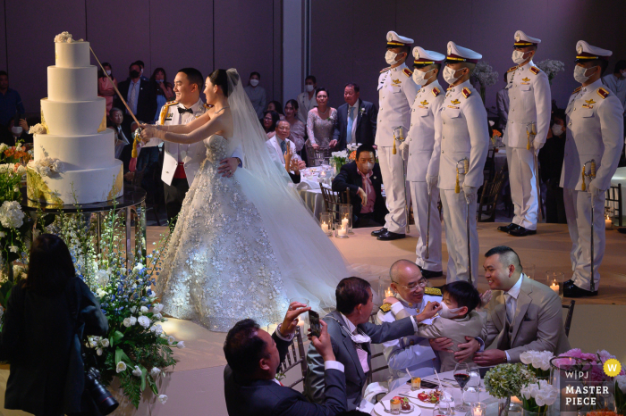 Fotografia documental de casamento premiada no concurso de Bangkok da cerimônia de corte de bolo da recepção de casamento asiática