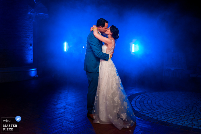 bride and groom first dance in blue lighting A wedding photographer in Italy created this image at the Castello di Spessa of the Gorizia Bride and groom first dance in blue lighting