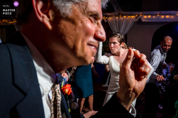 Immagine vincitrice di Alessandria dal miglior concorso di fotografia di matrimonio in stile documentario al mondo presso l'Hotel Alexandrian che cattura la sposa e suo padre che ballano con facce buffe