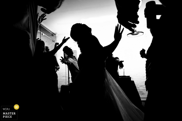 A DC photographer captured the bride dancing in a silhouette at Fathom Gallery in Washington DC in a wedding photograph