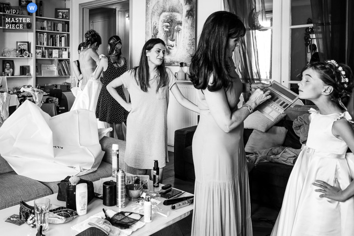 As the bride gets ready at a home in Centre-Val de Loire, a young bridesmaid undergoes makeup adjustments during the bridal preparations