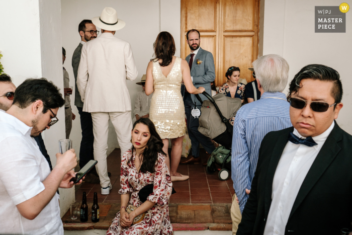 A movimentada cena da recepção do casamento durante a hora do coquetel estava repleta de convidados alegres No Museu Belber em Oaxaca, um fotógrafo local capturou uma cena movimentada de recepção de casamento durante o coquetel em uma pequena sala