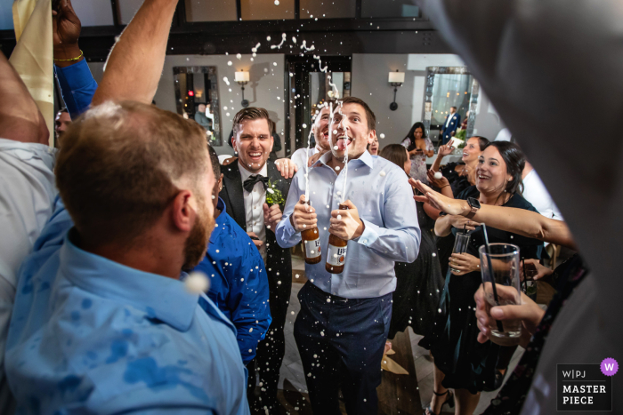 Na recepção do casamento, os convidados comemoraram alegremente a união borrifando cerveja na pista de dança Os convidados do casamento comemoraram o casamento com um spray de cerveja na pista de dança do Liberty Prime em Jersey City, Nova Jersey, capturado pelo talentoso fotógrafo da The Gallery