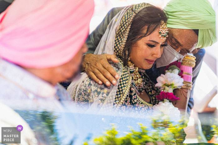 This beautiful wedding photograph captures the emotion of the moment as the bride's family lovingly bid her farewell after the ceremony The moment was captured at the Lake Oak Meadows Weddings and Event center in Temecula, California as the bride's family sends her off after the ceremony