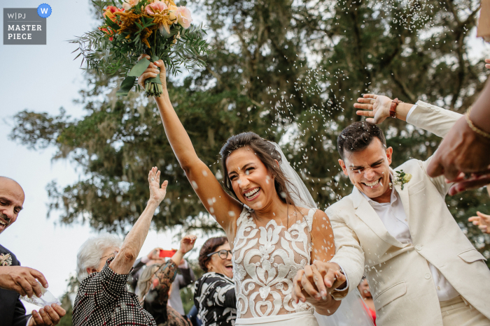 Outdoors at the Alameda da Figueira of Porto Alegre, the RS couple are celebrating on the way out with rice