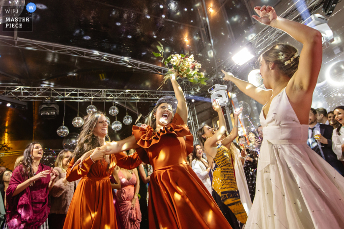 Wedding pic from the Villa Toscana venue in Bagé of the Godmother taking the bouquet excited and vibrating a lot