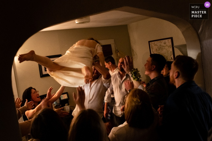 The blissful image of a bride being joyously thrown in the air at their lovingly crafted home-made wedding reception is one to be cherished forever Image from a private house in Madison, Wisconsin showing a bride gets tossed at their homemade reception