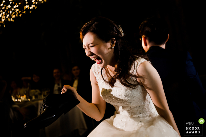 The bride and groom laugh and smile while playing the shoe game at the reception venue From a wedding at a Perth Western Australia Reception Venue, the bride plays the shoe game