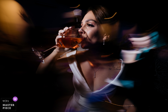 A wedding picture captured a slow shutter motion blur of a woman drinking from a glass on the party dance floor in São Caetano do Sul, São Paulo