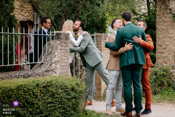 Ardèche Couple Shares Heartfelt Embrace at Courtyard Exit in Stunning Wedding Day Moment Ardèche, Auvergne-Rhône-Alpes - Emotional embraces at the courtyard exit after the wedding ceremony.