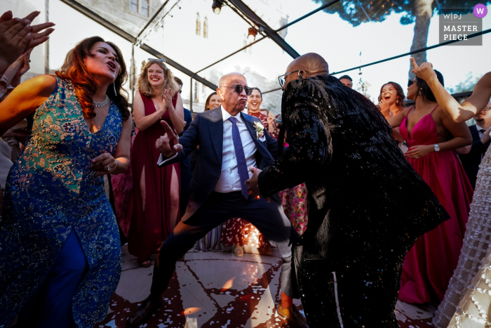 Borgo Pignano, Pisa, Italy - The father of the groom takes center stage on the dancefloor, showing off his impressive moves and stealing the show at the wedding celebrations.