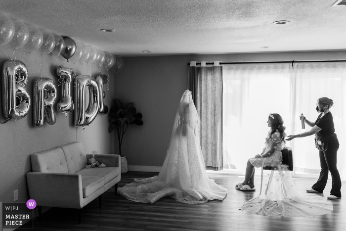 Wedding Excitement - Bride Admires Dress & Gets Hair Done in San Jose, CA Captivated by the beauty of the bride's dress, she eagerly awaits her wedding day while getting her hair done in San Jose, CA.