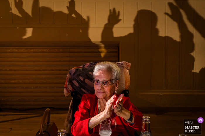 French Grandmother's Festive Wheelchair View in a Old Church | Rustic Charm Abounds Amidst the rustic charm of a former church in France, a beaming grandmother relishes in the joyous celebration from her wheelchair.