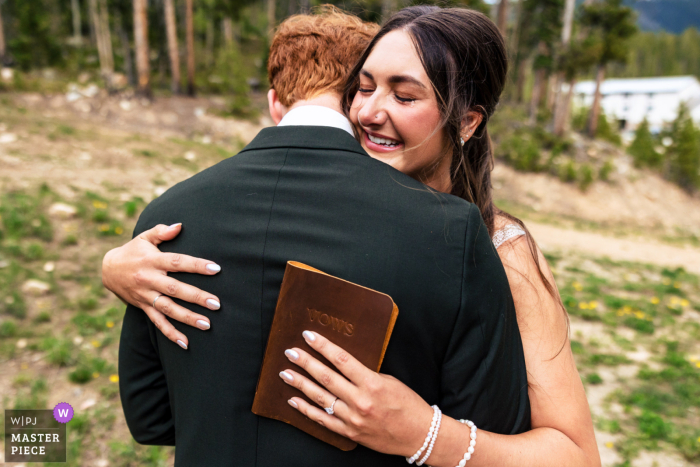 Surrounded by the beauty of Denver, Colorado, the bride happily embraces her groom after sharing their personal vows at their hotel.