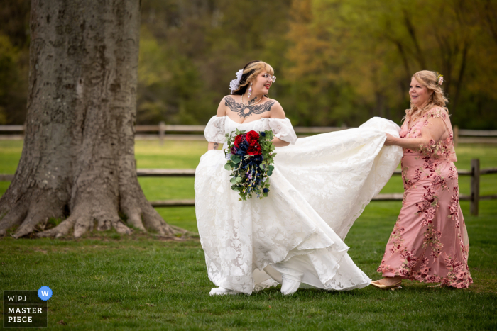 A heartwarming moment as the bride's mom guides her on the grass, surrounded by the picturesque beauty of Pen Ryn River's Edge in Bensalem, PA.