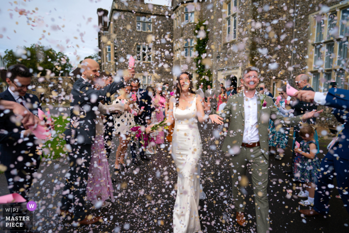 Snowing Confetti at Stunning House: Bride & Groom's Unforgettable Sussex Wedding Bride and groom were surrounded by a beautiful burst of confetti outside the stunning Slindon House in Sussex, UK.