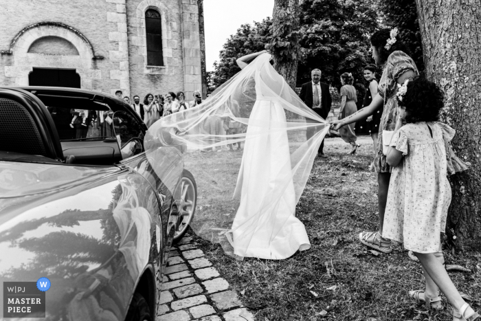 The bride gracefully arrived at the front of Vienne Church, her veil blowing in the wind, ready to embark on her special day.