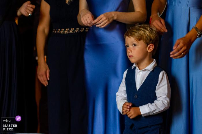 Intrigued Kid Observes Bride & Bridesmaids at Sicilian Venue A curious child watches as the bride and her bridesmaids act differently than usual, puzzled by the events unfolding at the beautiful Giardini Naxos in Sicily.