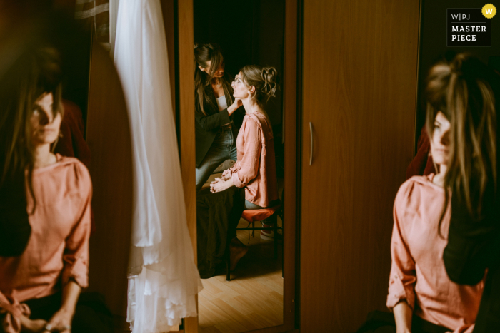 Capturing the bride's transformation into a stunning bride, the artist's skilled hands and two mirror reflections provide a beautiful visual in Gers, France.