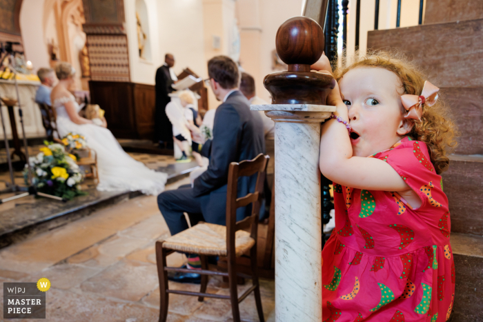 Curious Girl Watches as Couple's Union is Blessed in Charentay Church Ceremony While the couple's union was being blessed in the traditional ceremony, a curious little girl watched with awe and wonder in Charentay.