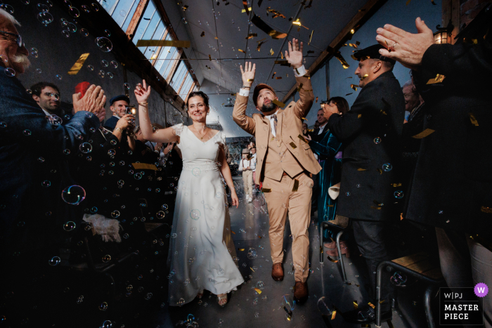 Newlyweds Dance at Night for Grand Exit at La Factory Thizy les Bourgs in a Flurry of Bubbles and Confetti Amidst a flurry of bubbles and confetti, the newlyweds make their grand exit from La Factory Thizy les Bourgs, captured by a WPJA photographer.