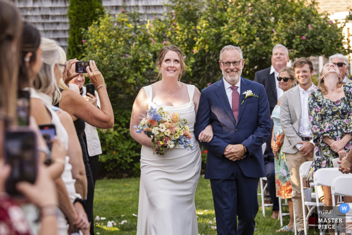 Cape Cod Wedding: Bride & Father's Proud Aisle Walk at Osterville Historic Society Love and laughter filled the air as the bride and her father proudly walked down the aisle at the Osterville Historic Society for this stunning Cape Cod wedding.