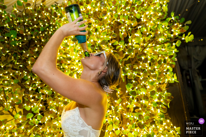 The bride celebrates in true unapologetic fashion, taking a swig straight from the bottle at the vibrant Twin Oaks Wedding Venue in San Marcos, CA.