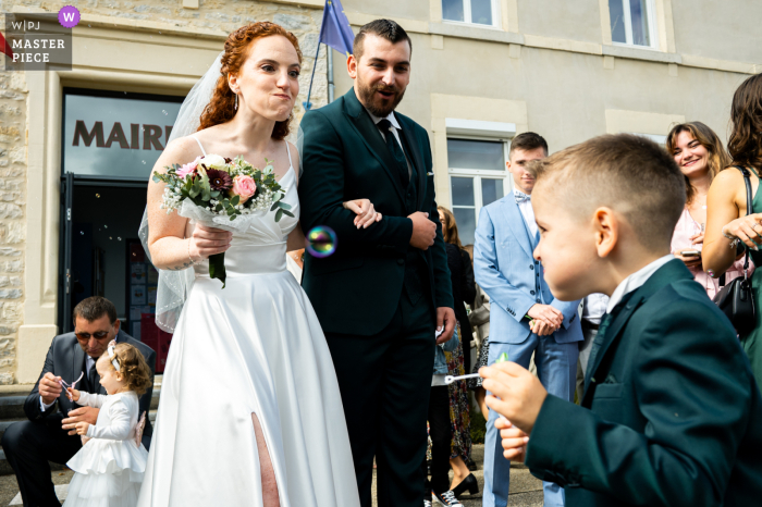 Newlyweds Share Laughter and Silly Faces with Little Guest at Saint Didier d'Aussiat City Hall Ceremony The newlyweds couldn't hold back their laughter as the bride shared a silly face with a little guest after their city hall ceremony in Saint Didier d'Aussiat, France.