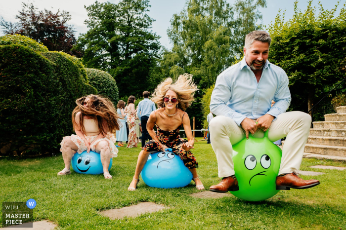 Adults at Owlpen Manor race to the finish line on space hoppers, capturing joy and youthfulness. Packed with playfulness and lively energy, the adults at Owlpen Manor race to the finish line on their space hoppers, capturing the joy and youthfulness of the day.