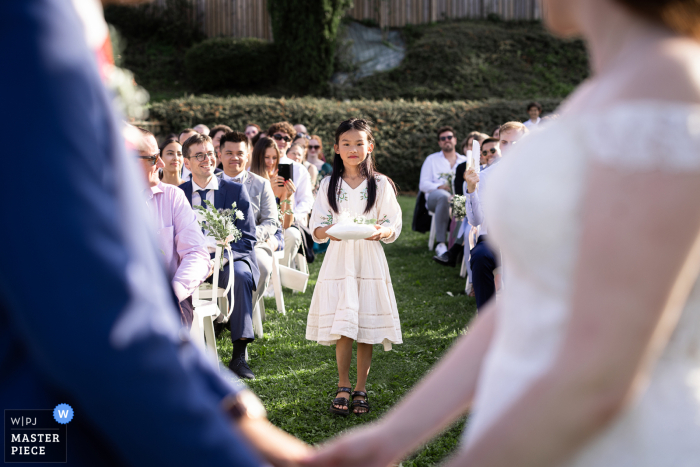 At Hotel Les Trésoms in Annecy, anticipation fills the air as the wedding rings make their grand entrance, symbolizing the union about to be celebrated amidst breathtaking views.