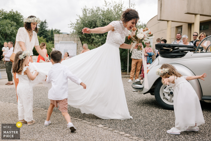Daughter Looks on with Wonder as Mother Dresses for Wedding in Auvergne-Rhône-Alpes Before the ceremony unfolds in Auvergne-Rhône-Alpes, a daughter is captivated, her face lighting up with wonder upon seeing her mother beautifully dressed for the wedding.