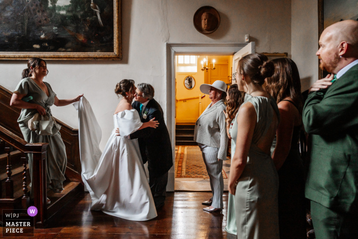 At Smedmore House, Dorset, the bride and her dad share a heartfelt embrace, savoring a tender moment together before she departs for the much-anticipated ceremony. 