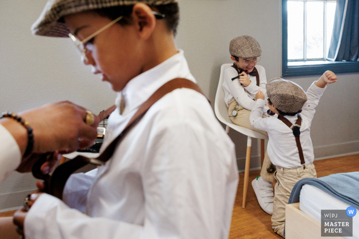 Playful Scuffle Among Bride and Groom's Children Adds Humor to Wedding Preparations at La Factory in Thizy-les-Bourgs At La Factory in Thizy-les-Bourgs, as the bride and groom's children prepare for the event, a playful scuffle breaks out between two of them in the background. This candid moment adds a touch of humor and familial energy to the preparations.