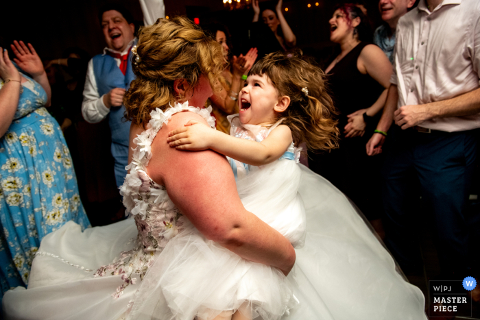 Bride joyfully dances with a young girl at Madison Beach Hotel, Madison, CT, sharing a sweet, heartfelt wedding moment together.