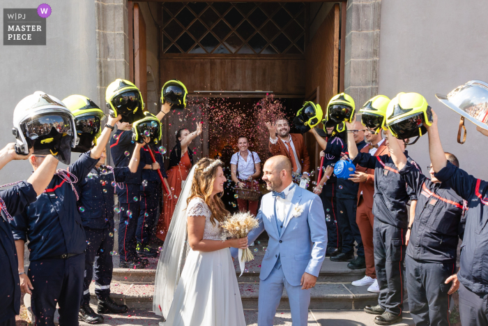 In Châtel-Guyon, France, newlyweds walk through a tunnel of raised firefighter helmets. The award-winning photo highlights the photographer’s skill at documenting this joyful, unique tribute to brotherhood and celebration, surrounded by confetti and bubbl