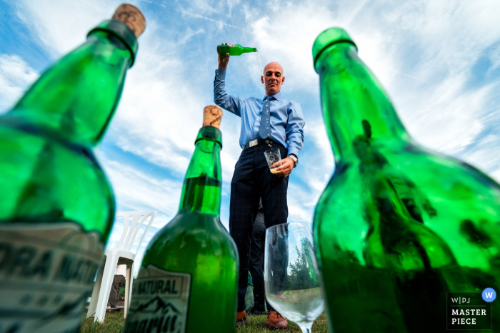 At Domaine Etxezahar in Bardos, France, the photographer captures the Spanish cider-serving tradition, using a low angle to highlight green glass bottles, showcasing cultural vibrancy and creative visual perspective.