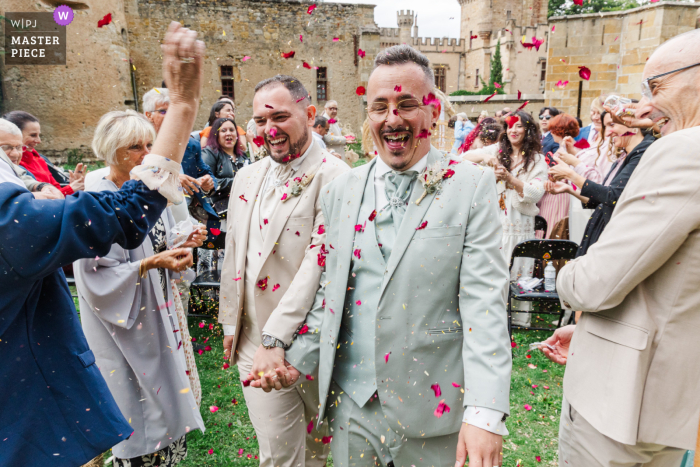 At Château Grange Fort in Puy de Dôme, a joyful burst of laughter and red petals surrounds the newlyweds as they celebrate their union after saying “yes.”