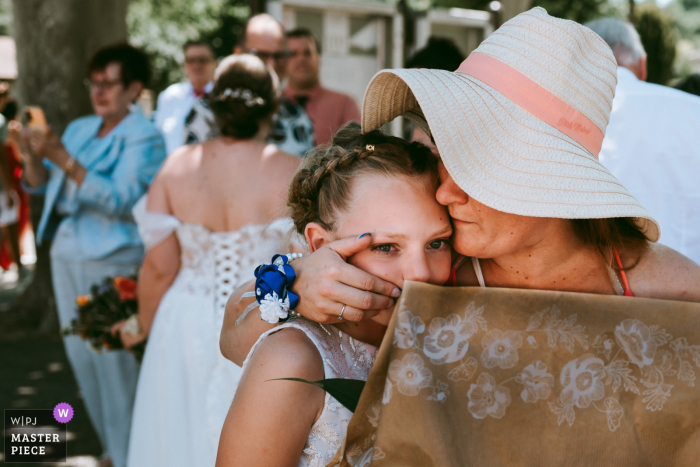   At Mairie d'Estillac in Lot et Garonne, a caring aunt gently comforts her young niece, offering warmth and reassurance during the wedding gathering.