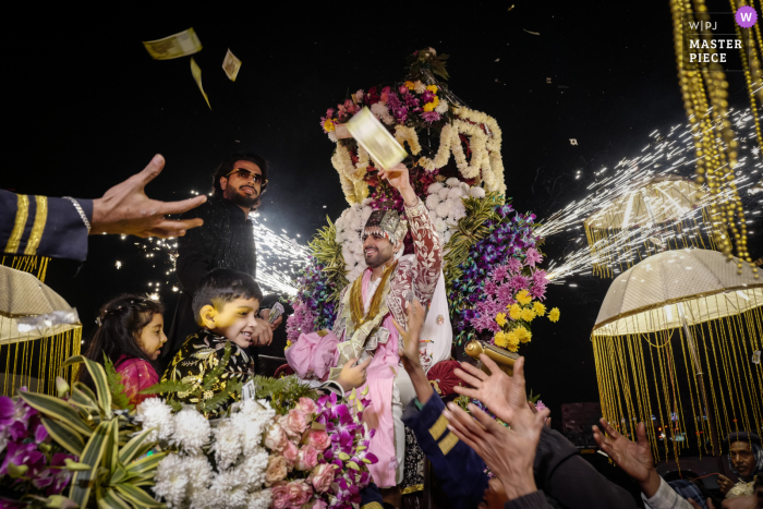   Lively negotiations and humor are on display during a traditional Give me money exchange at a wedding in Delhi, India, where guests enthusiastically join the fun.