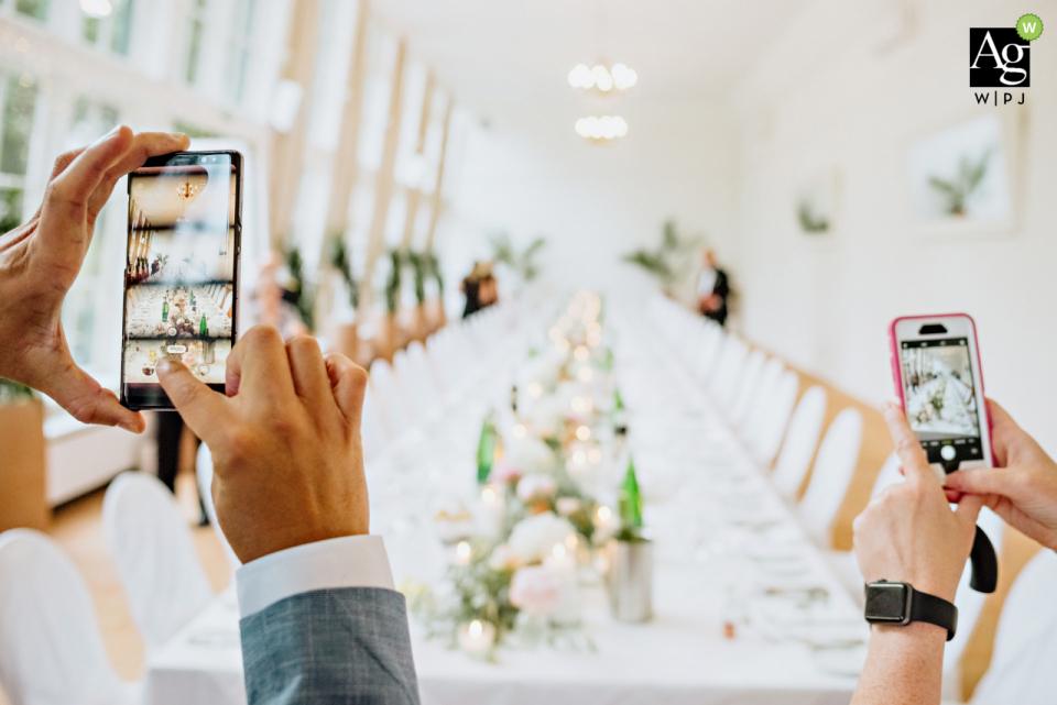 invités de mariage prenant des photos avec des téléphones-appareils photo de la table de réception Europahaus Vienna Invités de mariage prenant des photos. | Photographie détaillée des téléphones-appareils photo et de la table de réception