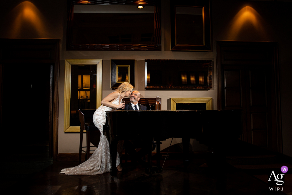 Foto de: <a href="https://www.wpja.com/photos/artistic-wedding-photographers/2577500"> Orçun Yalçın - Ankara Ankara Foto de boda del Swiss Hotel Bosphorus | El novio está tocando el piano y la novia está sentada junto a él y están matando y bebiendo champán