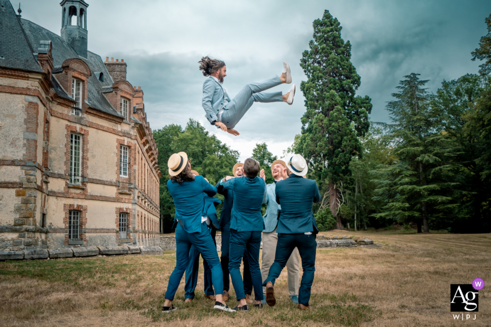 Château de Neuville, Frankreich Hochzeitsbild des Bräutigams, der von den Männern in die Luft geworfen wird Château de Neuville, Frankreich Hochzeitsbild des Bräutigams, der von den Männern in die Luft geworfen wird