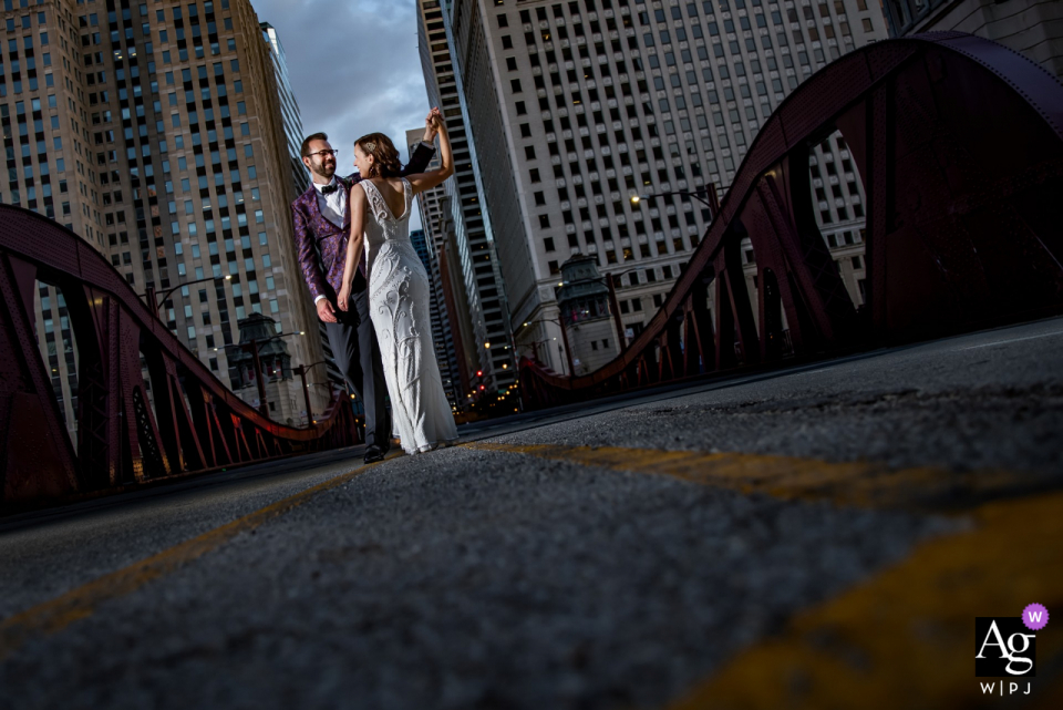 Newlywed couple portrait on a bridge by their reception at the River Roast in Chicago, IL Newlywed couple portrait on a bridge by their reception at the River Roast in Chicago, IL