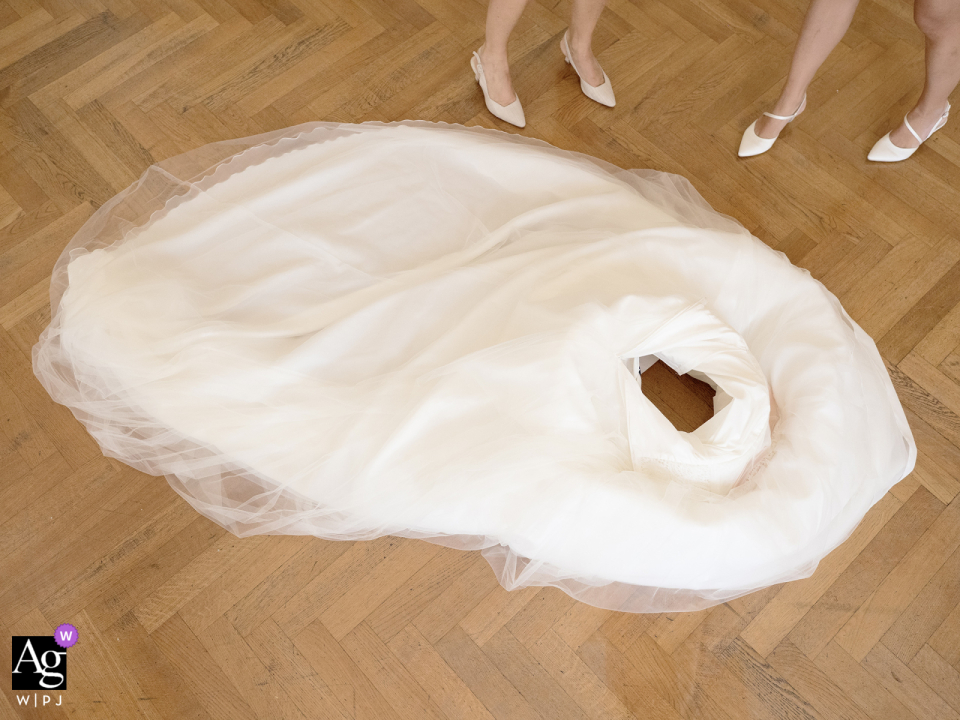 A beautiful wedding dress lies on the ground, eagerly awaiting its bride's arrival