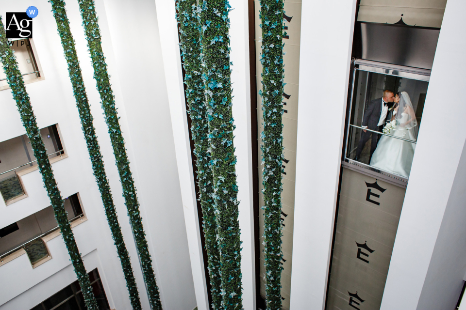 No elevador do hotel elexus, kyrenia, chipre, um retrato do dia do casamento dos noivos Uma noiva e um noivo radiantes compartilharam um passeio de elevador no dia do casamento, capturados em uma sessão especial de retratos em um hotel